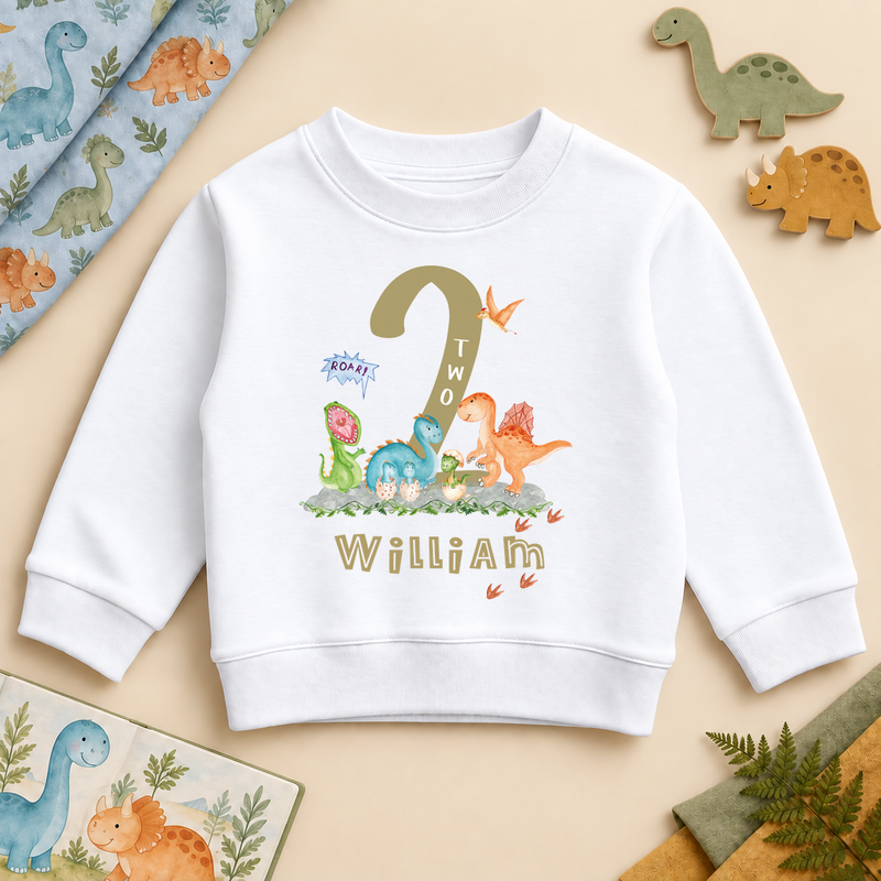 White second birthday sweatshirt with gold-coloured number two, colourful dinosaurs, footprints and example name William.