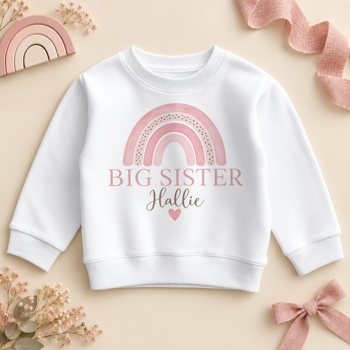 Personalised Big Sister sweatshirt with a soft pink watercolour rainbow, the name in script and a small heart