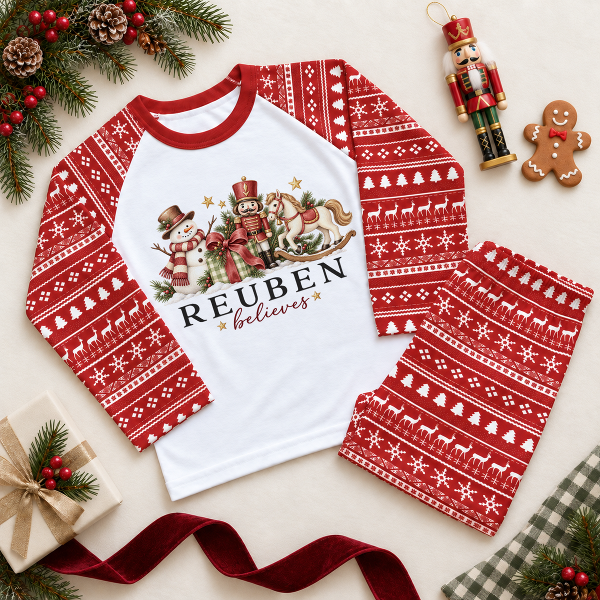 Red and white Christmas pyjama set with a snowman, nutcracker, rocking horse and ribboned gift. Reuben believes example personalisation.