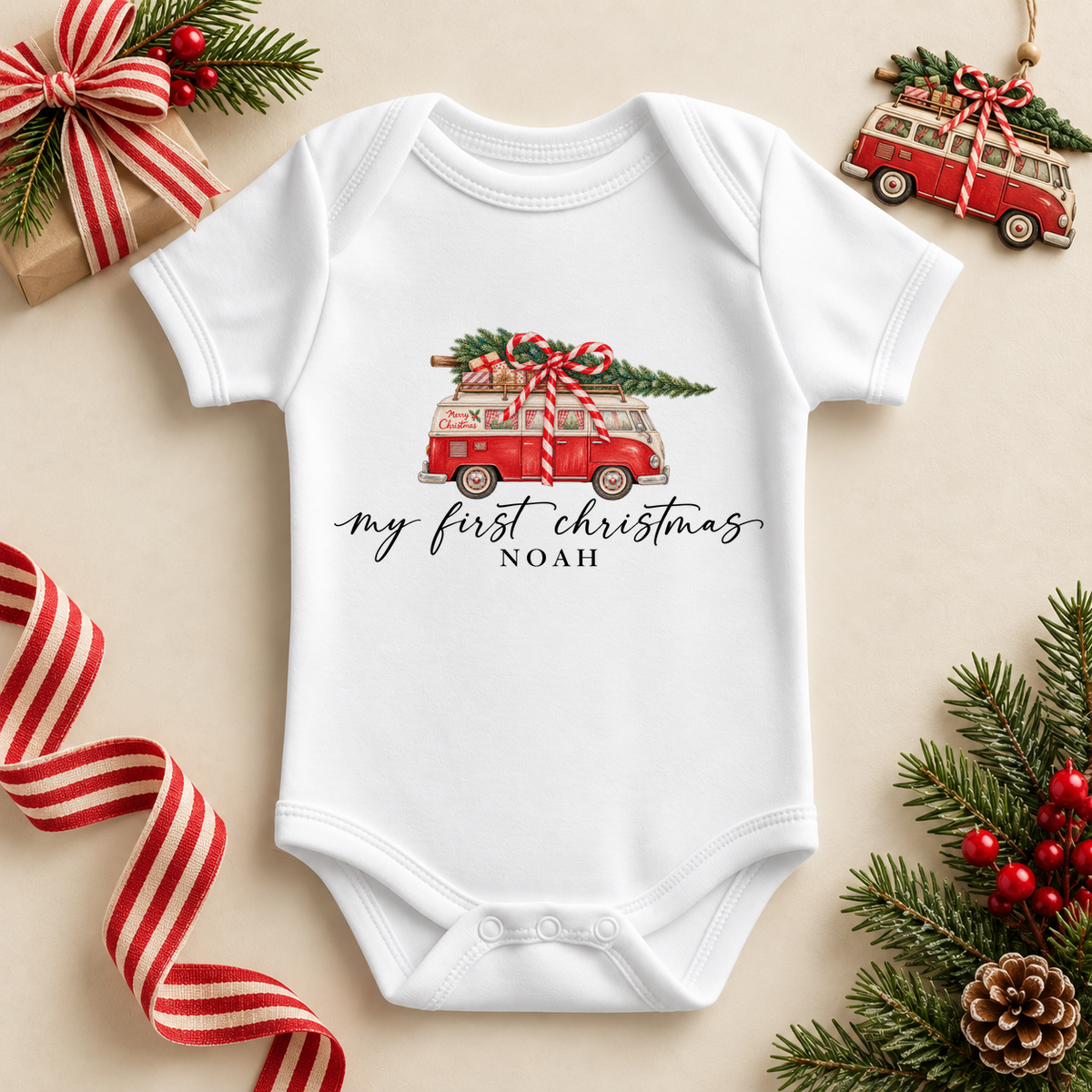 White baby bodysuit. The print features a red vintage campervan carrying a tree and ribboned presents.