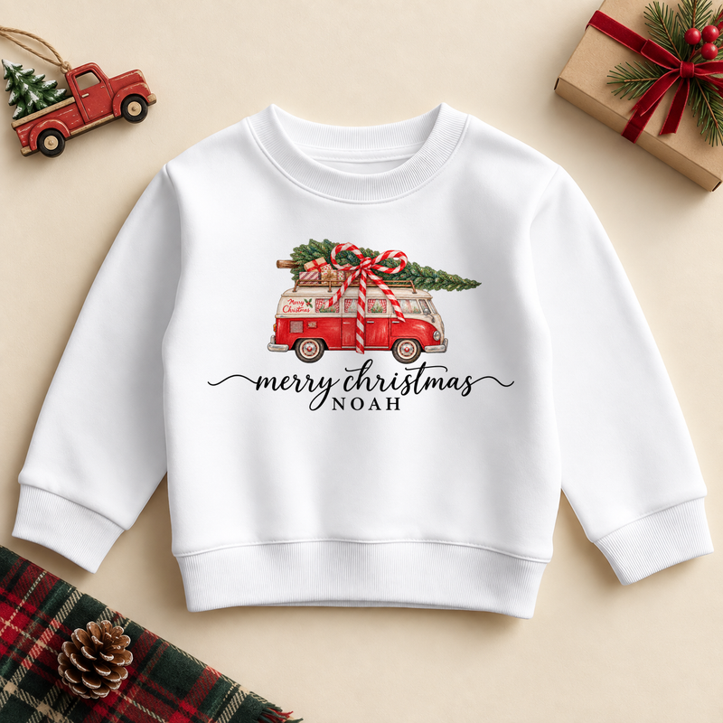 White children’s sweatshirt. The print features a red vintage campervan carrying a tree and ribboned presents.