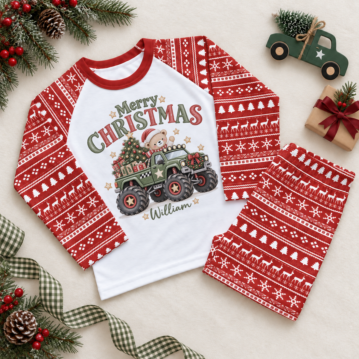 Red and white pyjama set. The print features a green monster truck carrying a teddy bear, tree and presents.