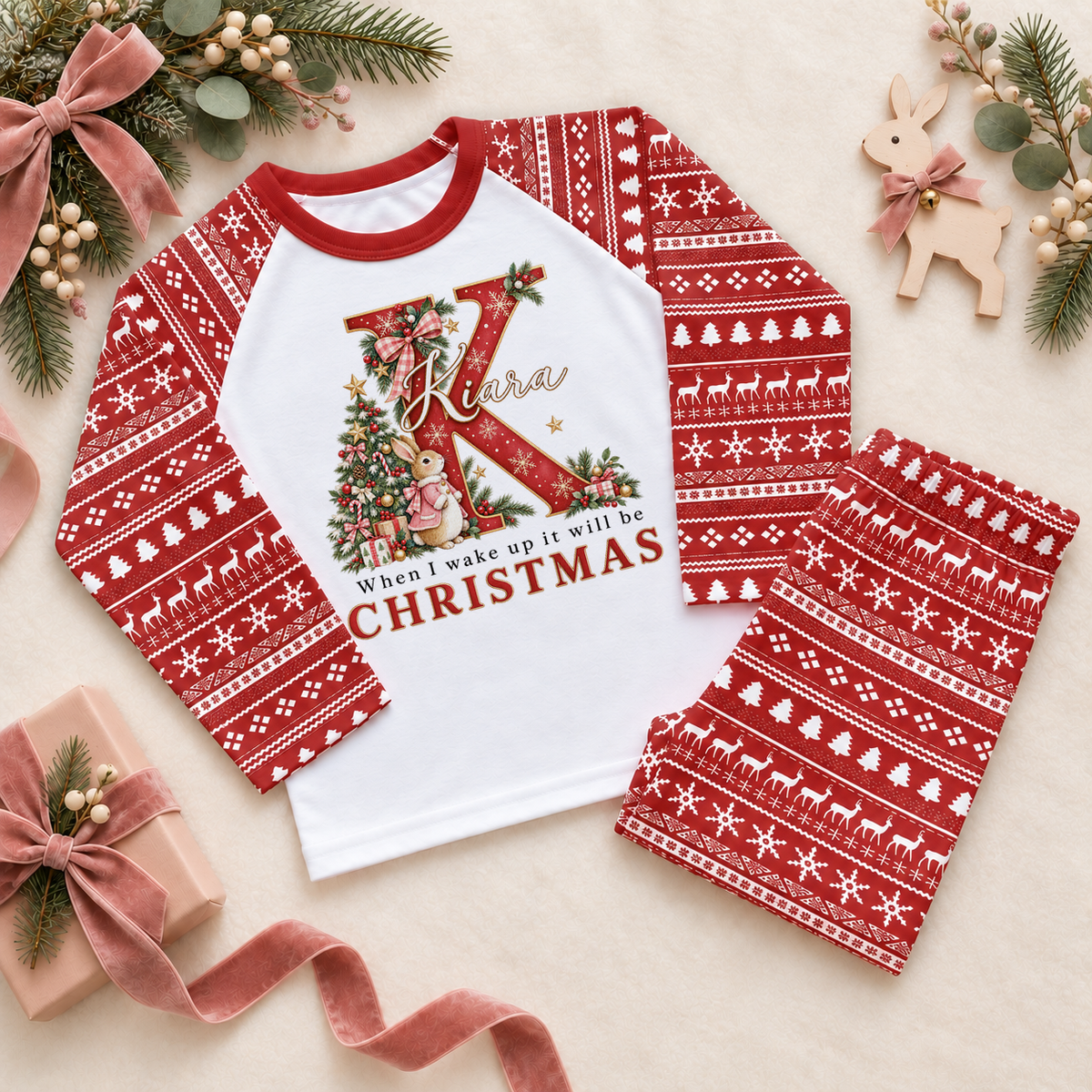 Red and white pyjama set. The print features a red initial beside a pink-coated bunny and a decorated Christmas tree.