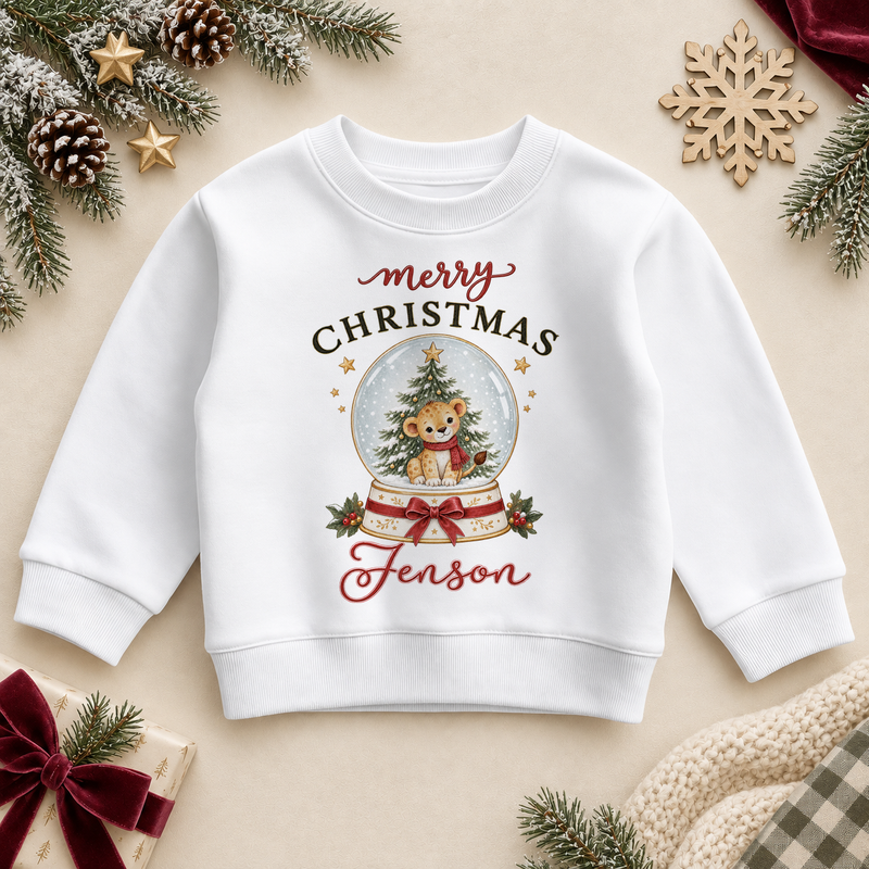 White children’s sweatshirt. The print features a little cub in a snowy globe with a Christmas tree and a red bow.