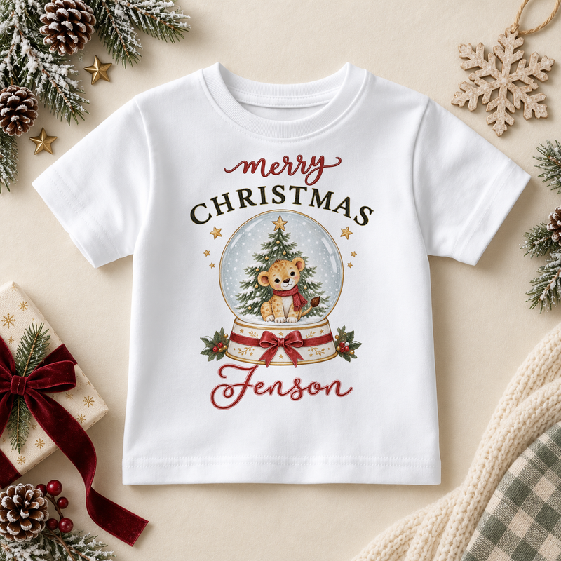 White children’s T-shirt. The print features a little cub in a snowy globe with a Christmas tree and a red bow.