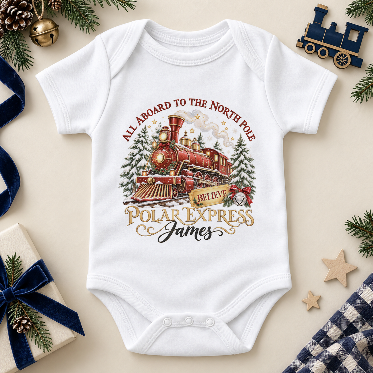 White baby bodysuit. The print features a red and brass steam train with snowy trees, a gold ticket and a silver bell.