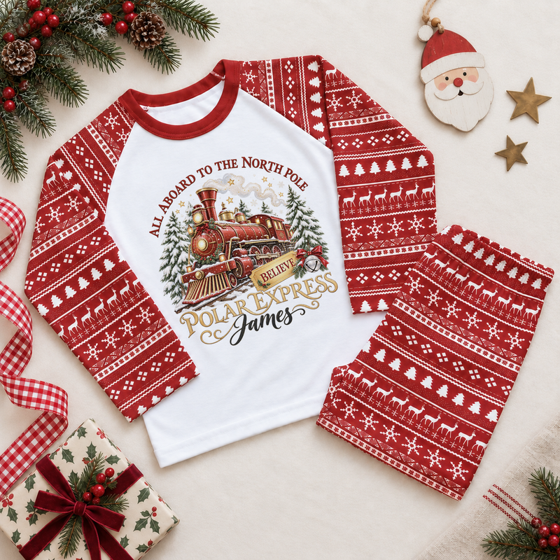 Red and white pyjama set. The print features a red and brass steam train with snowy trees, a gold ticket and a silver bell.