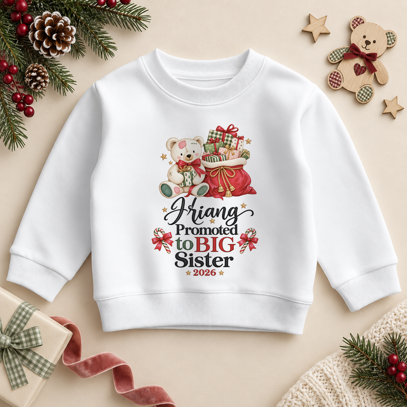 White children’s sweatshirt. The print features a teddy holding a gift beside a red sack of presents and Big Sister lettering.