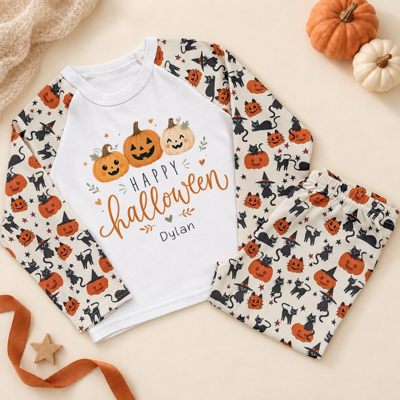 Personalised Halloween pyjama set with three smiling pumpkins design, white top and pumpkin-and-cat patterned sleeves and trousers.