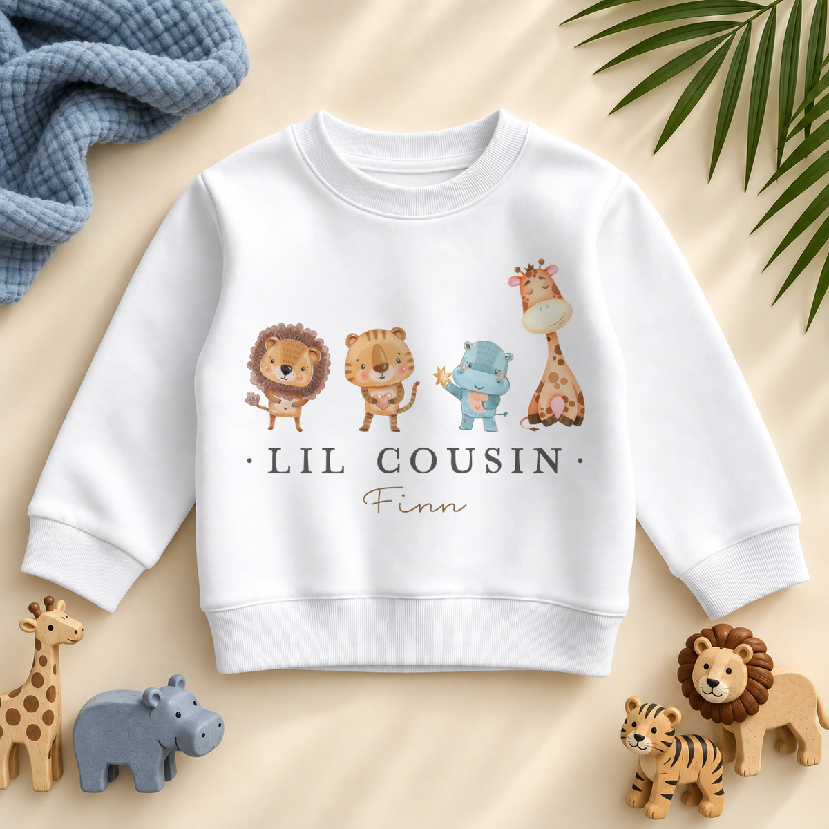 Lil Cousin safari animals sweatshirt personalised with Finn, with blue textile and matching safari toys.