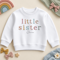 Personalised Little Sister white sweatshirt, pastel outlined serif letters with Olivia example name, styled with pastel rainbow and bows.
