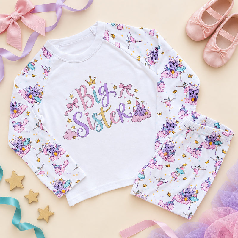 Big sister pyjamas with pastel script lettering, a gold crown, pink bows and a fairy castle on a white chest, with ballerina and princess castle print raglan sleeves and trousers