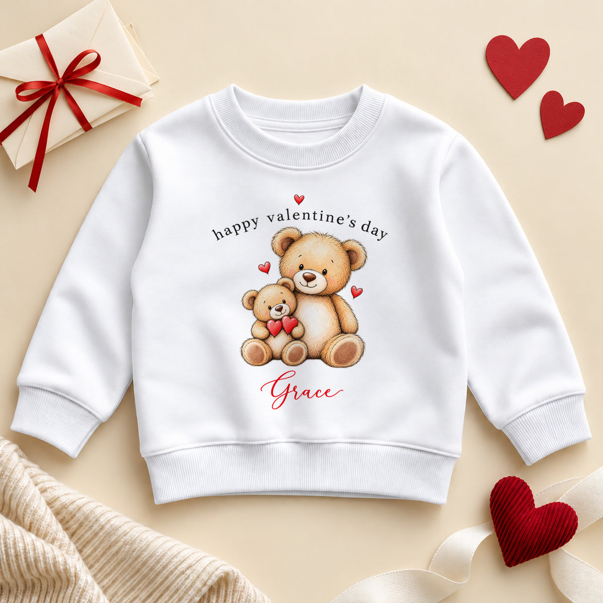 Personalised Happy Valentine's Day toddler sweatshirt: a white jumper with two cuddling teddy bears holding red hearts, black lettering and an example name