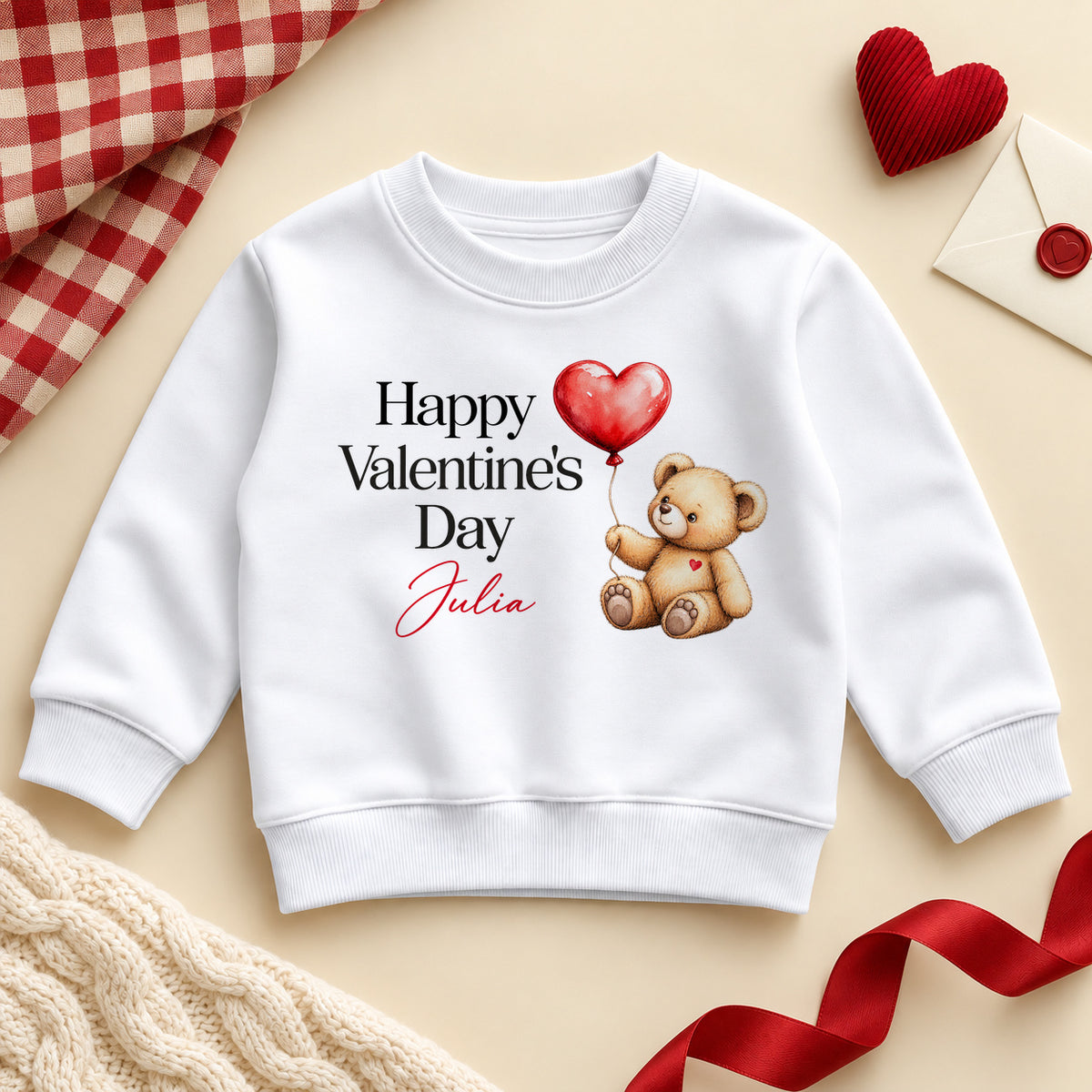 Personalised Happy Valentine's Day toddler sweatshirt: a white jumper with black serif lettering, a teddy bear holding a red heart balloon and an example name