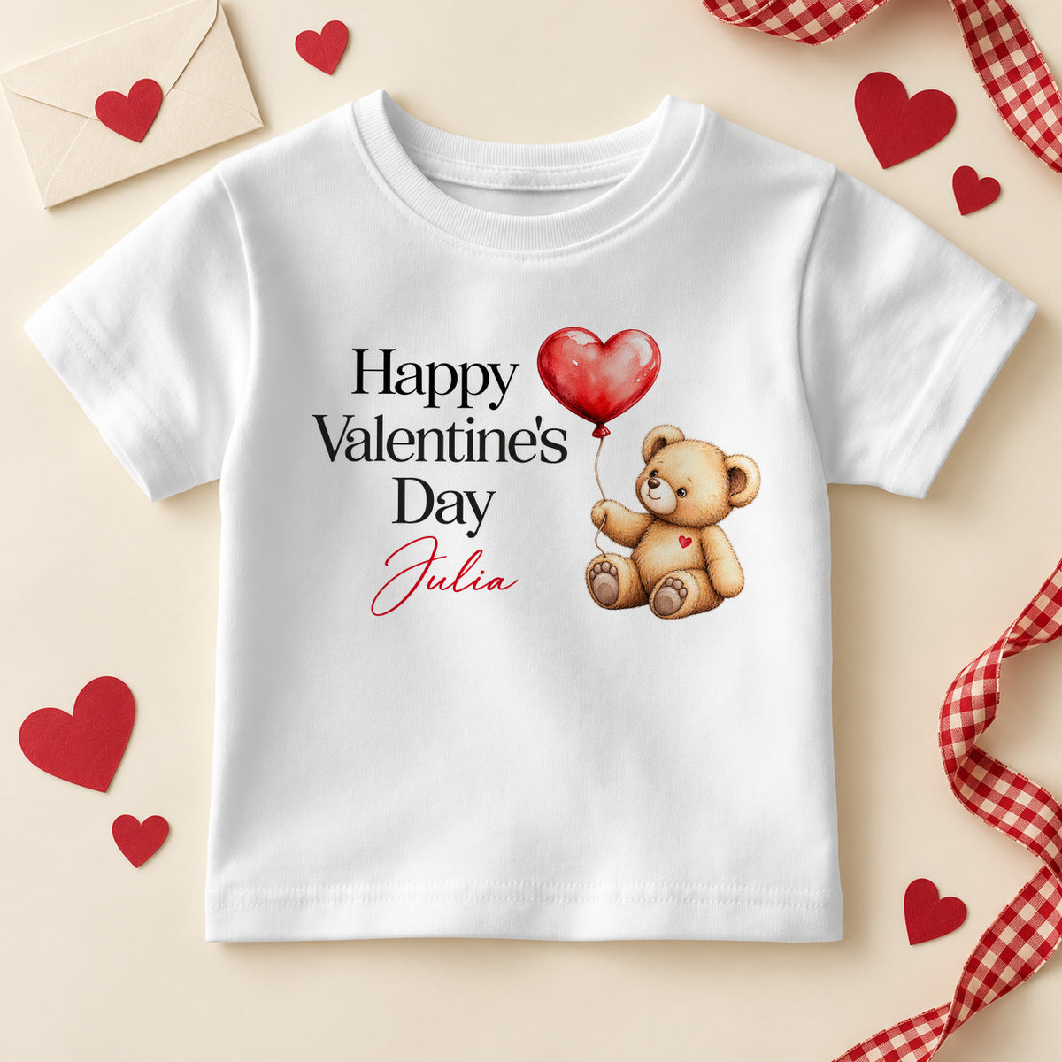 Personalised Happy Valentine's Day kids T-shirt: a white tee with black serif lettering, a teddy bear holding a red heart balloon and an example name