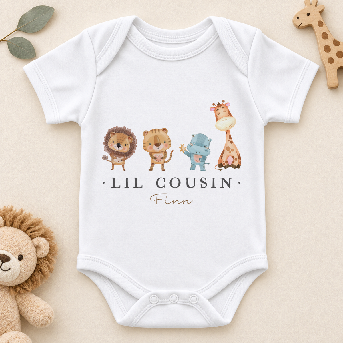 White personalised Lil Cousin baby bodysuit with lion, tiger, hippo and giraffe and Finn example name. Short sleeve version.