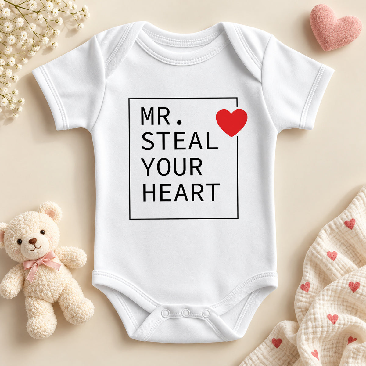 Mr Steal Your Heart baby bodysuit: a white baby vest with bold black capitals in a thin square frame and a red heart on the corner