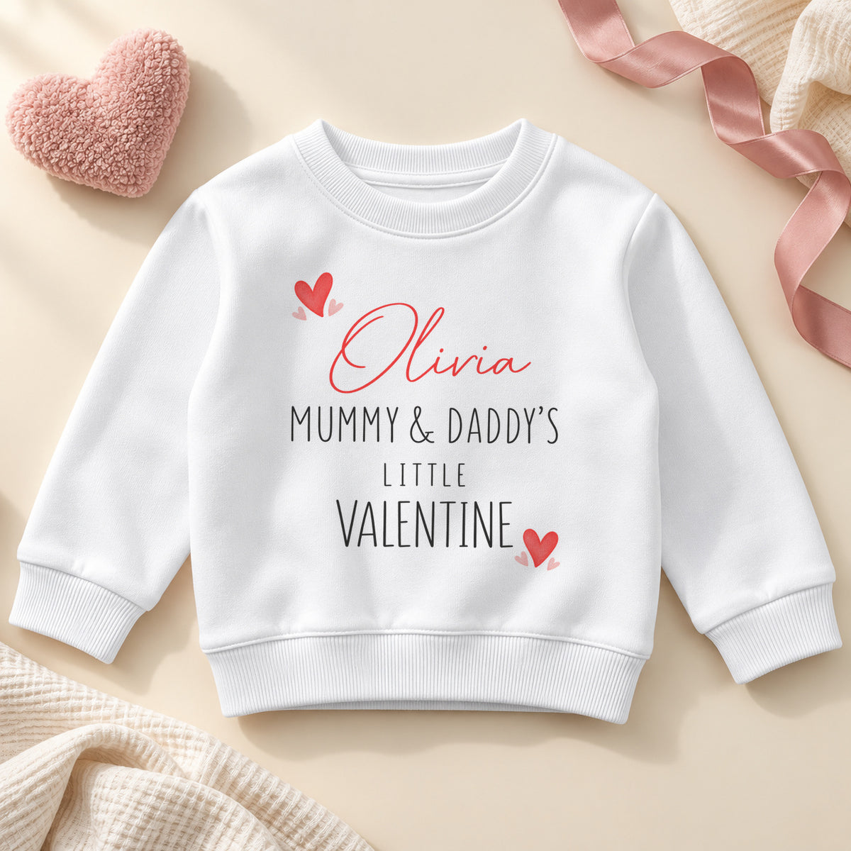 Personalised Mummy and Daddy's little valentine toddler sweatshirt: a white jumper with an example name in red script, black capitals and little red hearts