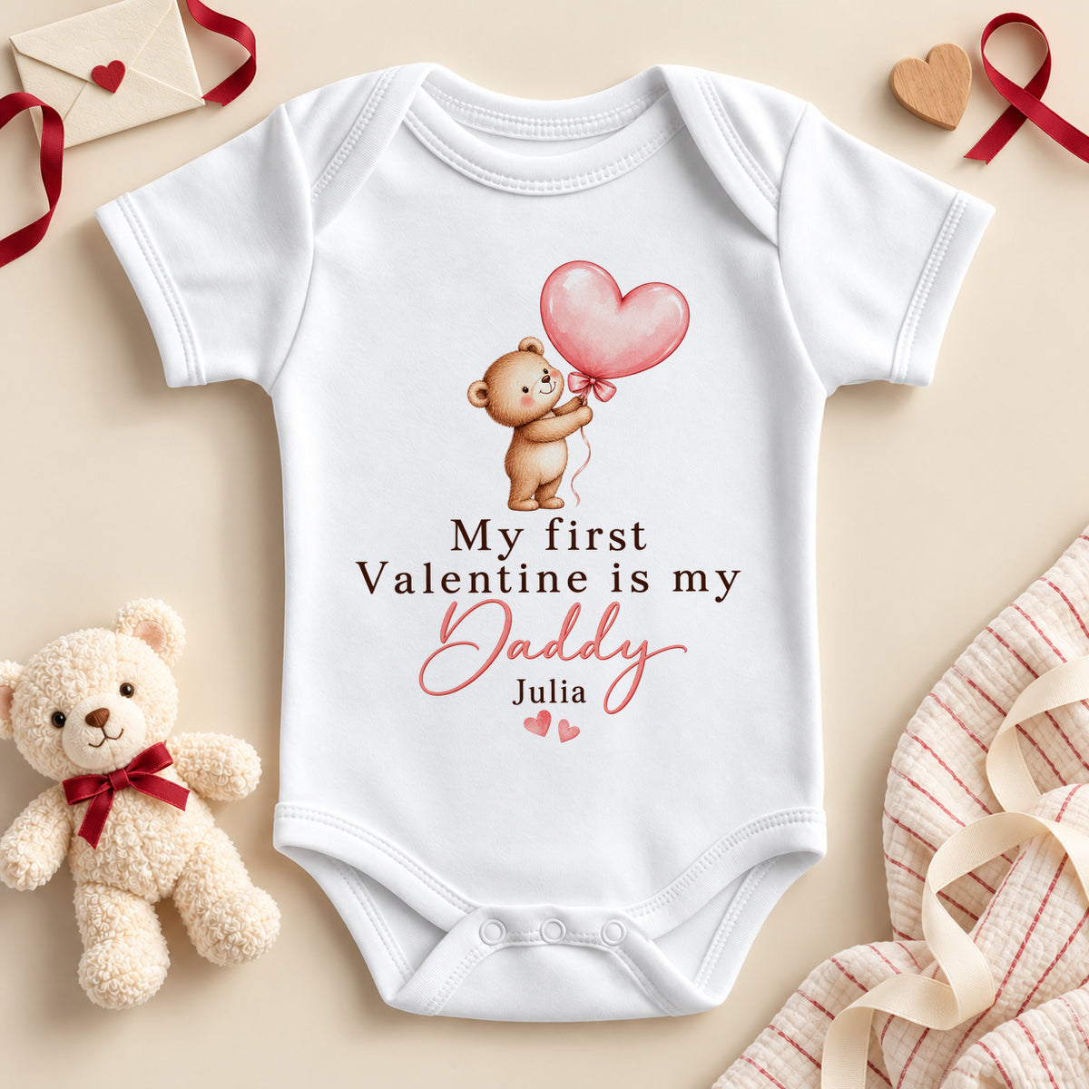 Personalised my first Valentine is my Daddy baby bodysuit: a white baby vest with a teddy bear holding a pink heart balloon, pink script and an example name