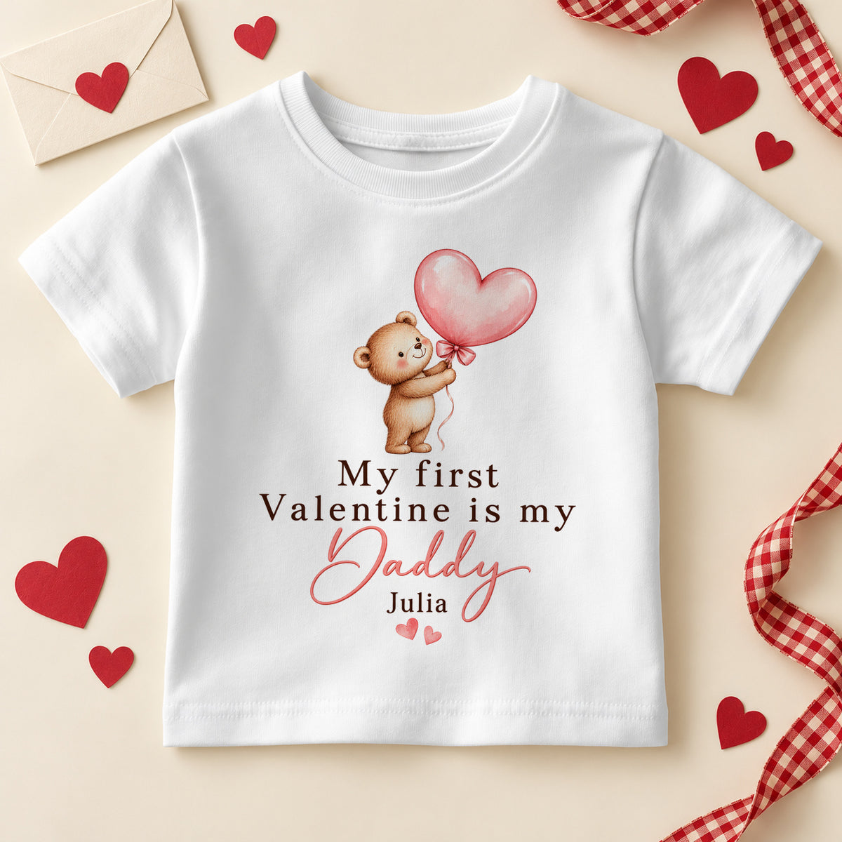 Personalised my first Valentine is my Daddy kids T-shirt: a white tee with a teddy bear holding a pink heart balloon, pink script and an example name