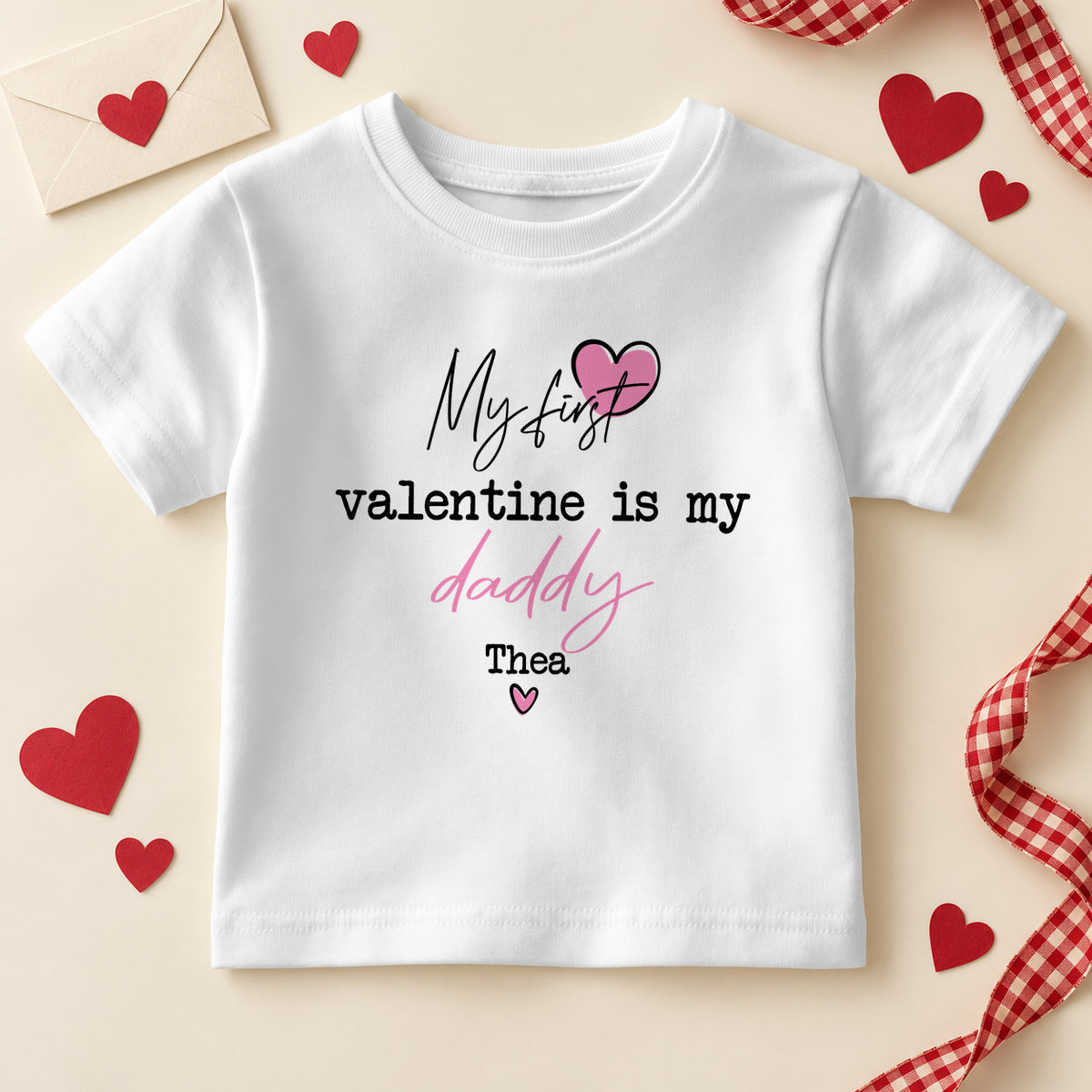 Personalised my first Valentine is my Daddy kids T-shirt: a white tee with script and typewriter lettering, a pink heart and an example name