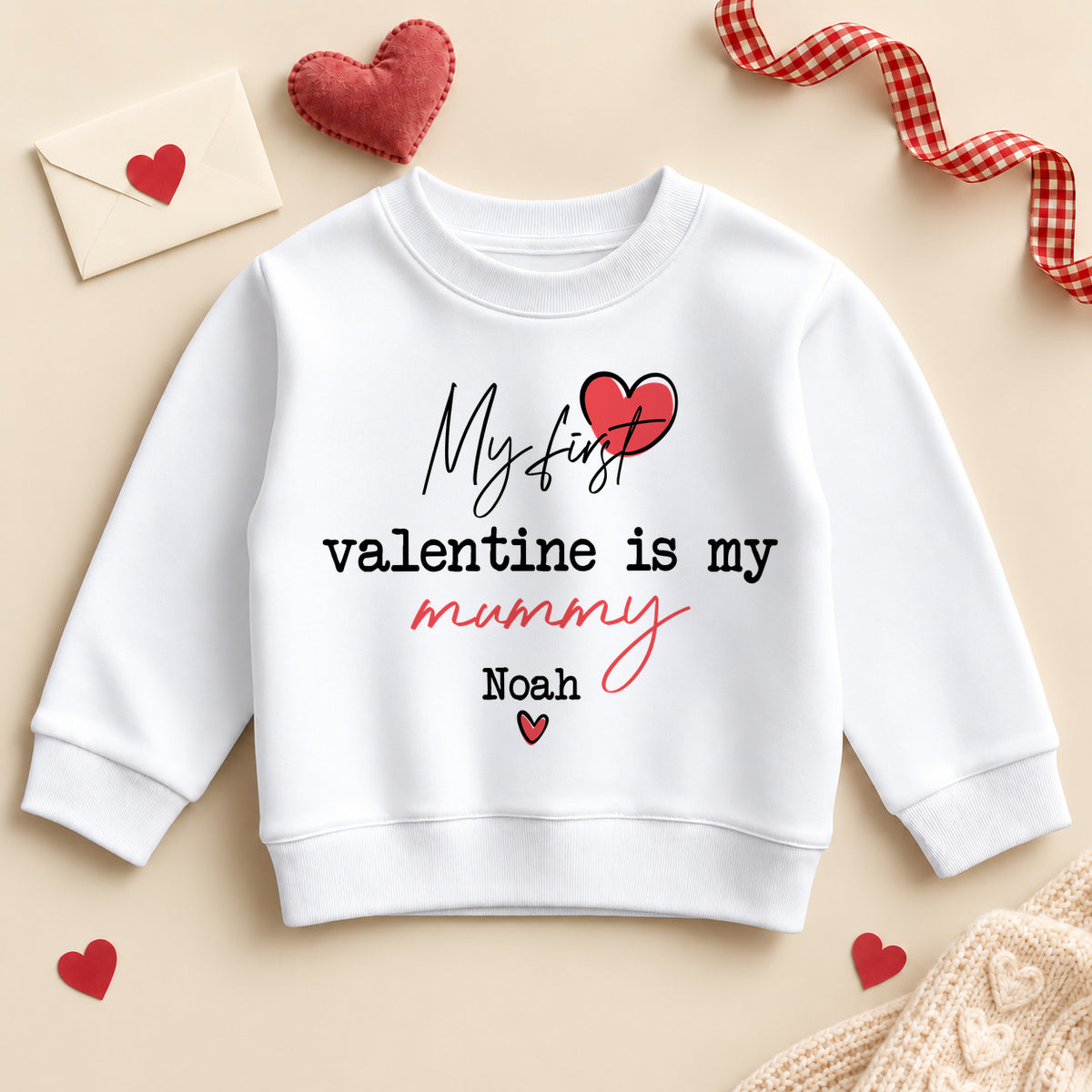 Personalised my first Valentine is my Mummy toddler sweatshirt: a white jumper with script and typewriter lettering, a red heart and an example name