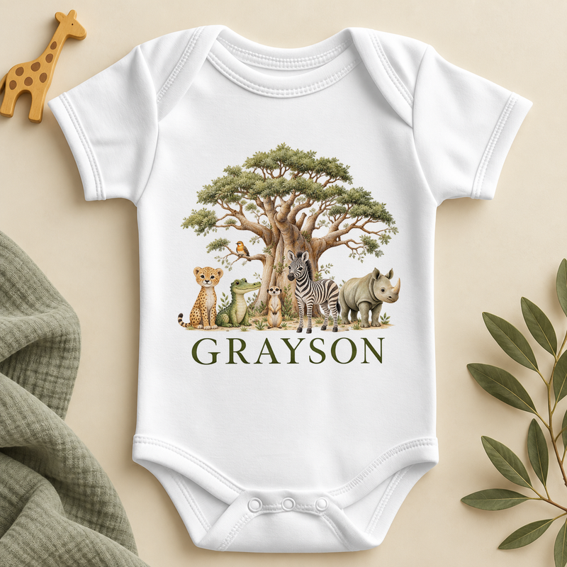 White short-sleeved baby bodysuit printed with a painted baobab tree, a small bird on a branch, a cheetah cub, a crocodile, a meerkat, a zebra and a rhino, with an example name in dark green capitals underneath.