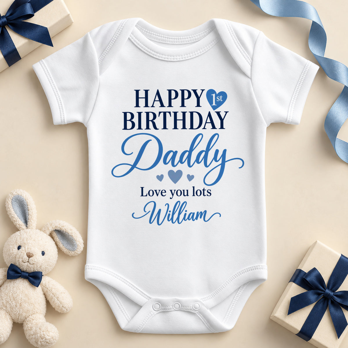 White short sleeve baby bodysuit printed Happy Birthday in navy capitals with 1st inside a blue heart, Daddy in blue script, Love you lots and the example name William.