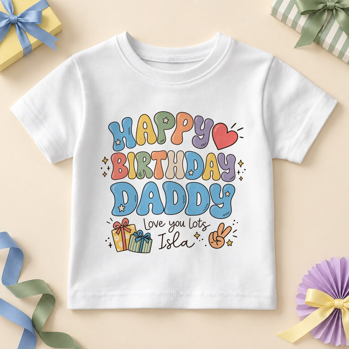 White kids T-shirt printed HAPPY BIRTHDAY DADDY in retro bubble letters with DADDY in soft blue, a red heart, stars, two gifts, a peace-sign hand, Love you lots and an example name.