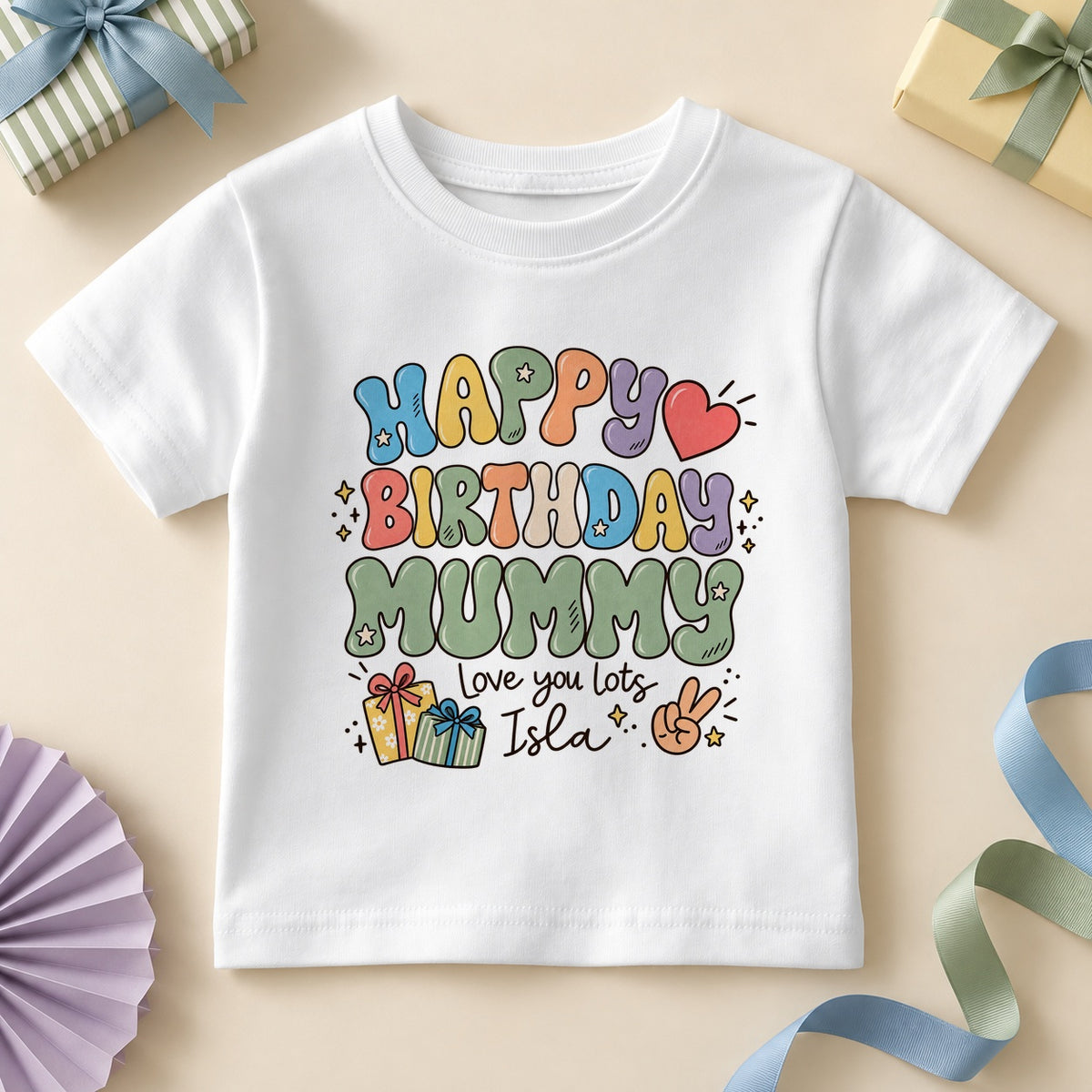 White kids T-shirt printed HAPPY BIRTHDAY MUMMY in retro bubble letters with MUMMY in soft sage green, a red heart, stars, two gifts, a peace-sign hand, Love you lots and an example name.