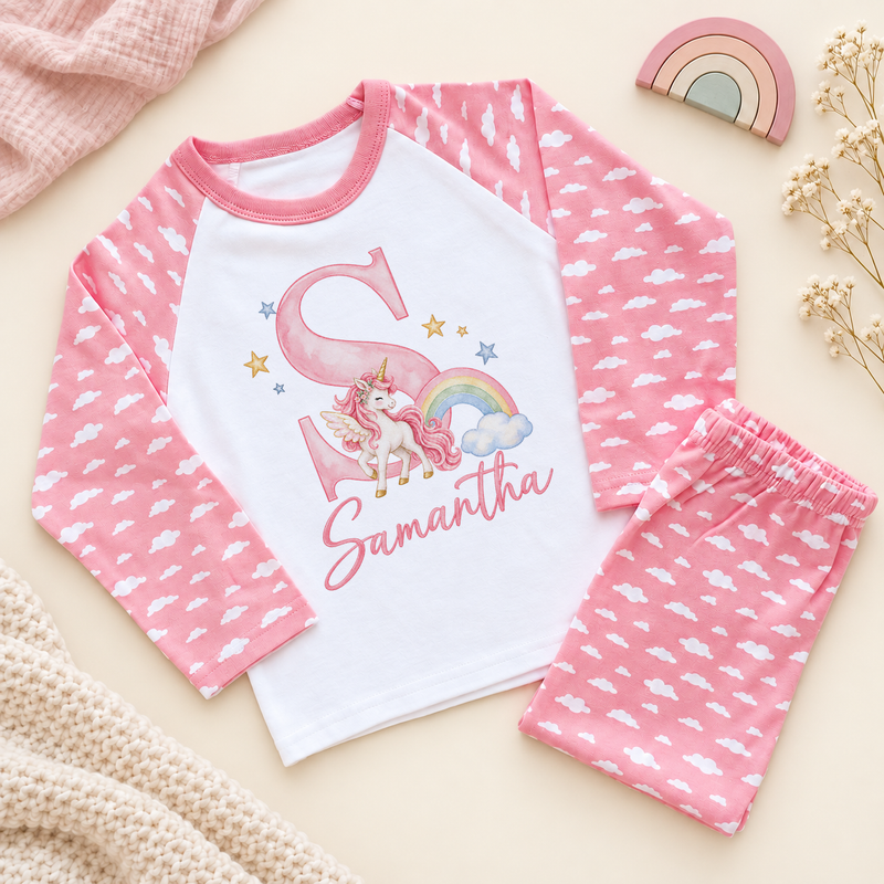 Pink cloud pyjama set with a watercolour unicorn, rainbow, initial S and Samantha example name on a white cotton top.