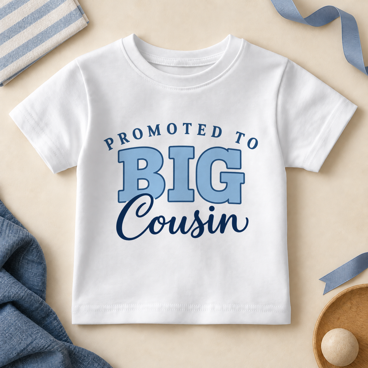 White promoted to big cousin kids T-shirt with PROMOTED TO in arched navy letters, BIG in light blue outlined letters and Cousin in navy script