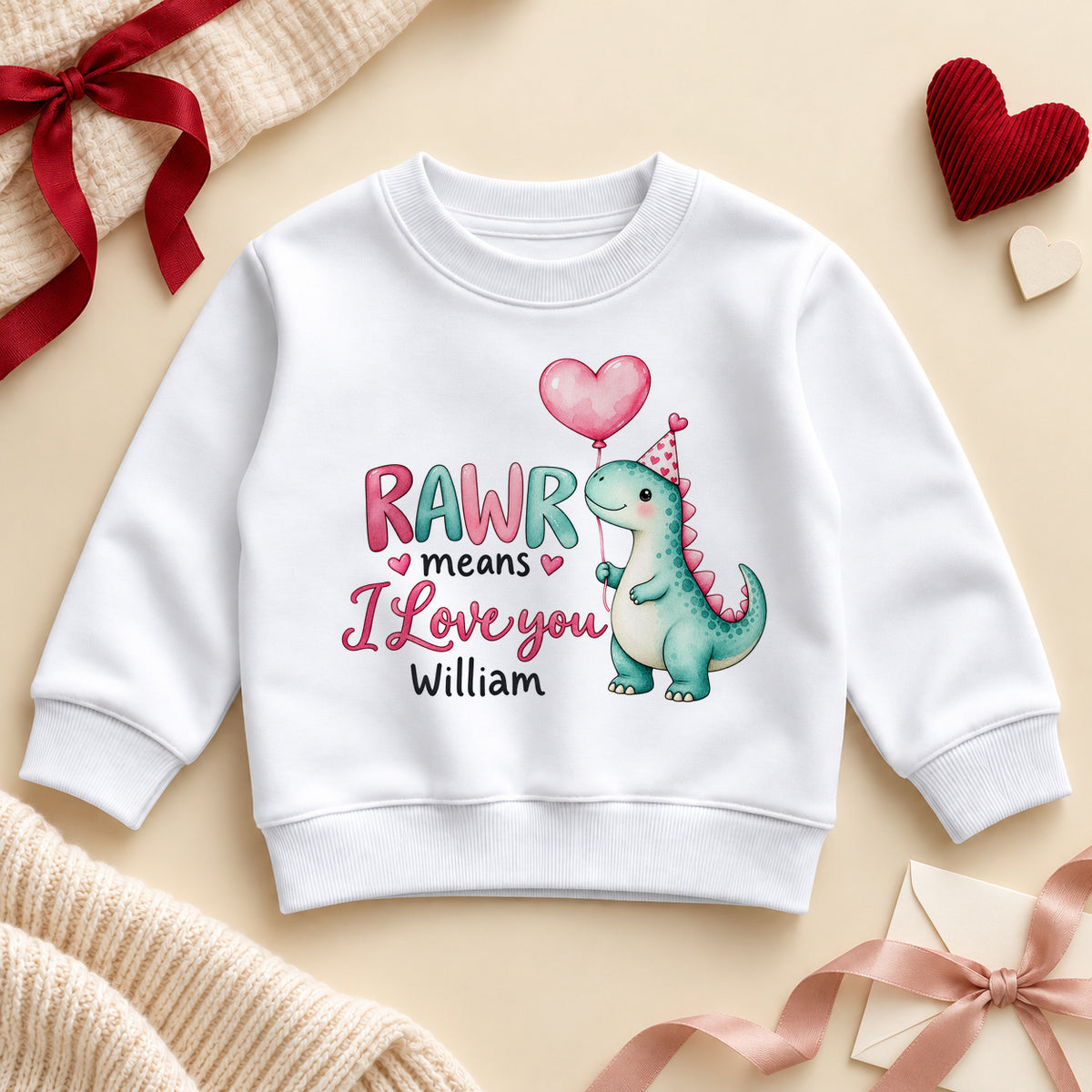 Personalised RAWR means I love you dinosaur toddler sweatshirt: a white jumper with a teal dino holding a pink heart balloon, pink and teal letters and an example name